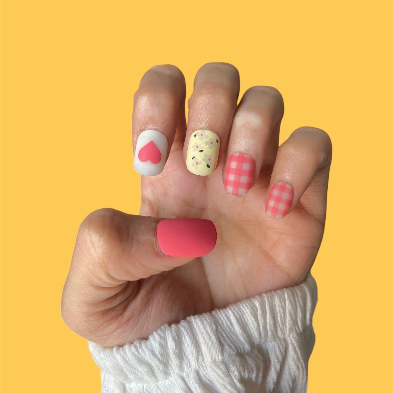 Close-up of press-on nails featuring a delicate and vibrant flower print design in various shades. The floral pattern includes intricate details, adding a touch of natural beauty to the nails.